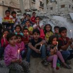 Palestinian,Children,Hold,Candles,As,They,Sit,On,The,Rubble